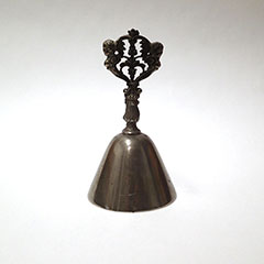Liturgical bell made of metal with a leaf-shaped handle.