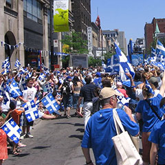 Personnes défilant dans les rues de Montréal lors du défilé annuel de la Fête nationale du Québec, la Saint-Jean-Baptiste.