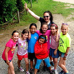 A group of children poses with their summer camp monitor.