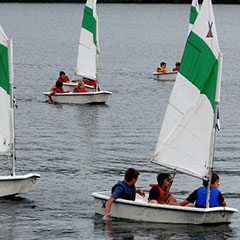 Children playing on small sailboats.