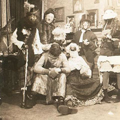 Six people in disguises and masks for the Mardi Gras festivities. They are gathered in a living room.