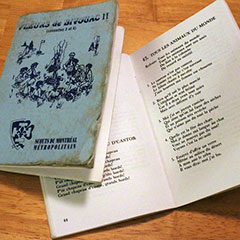 Deux recueils de chansons pour les scouts. La couverture d'un des recueils est visible, alors que l'autre recueil est ouvert.